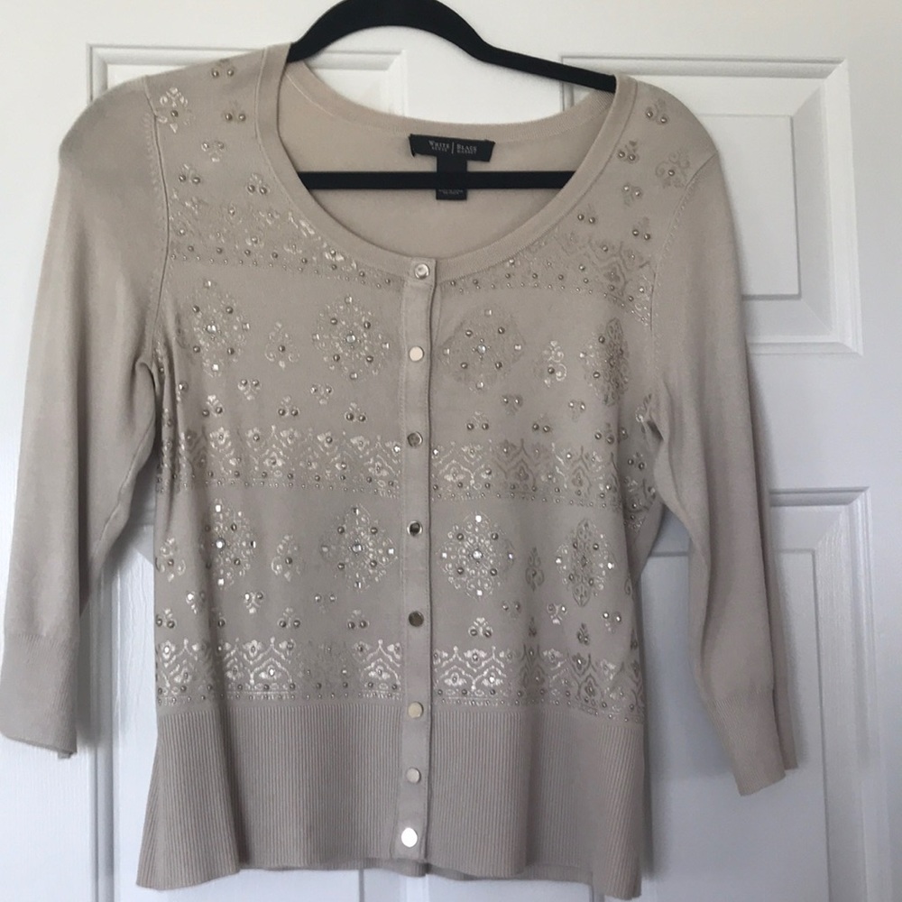 Light tan sweater, gold/ silver tone adornments.